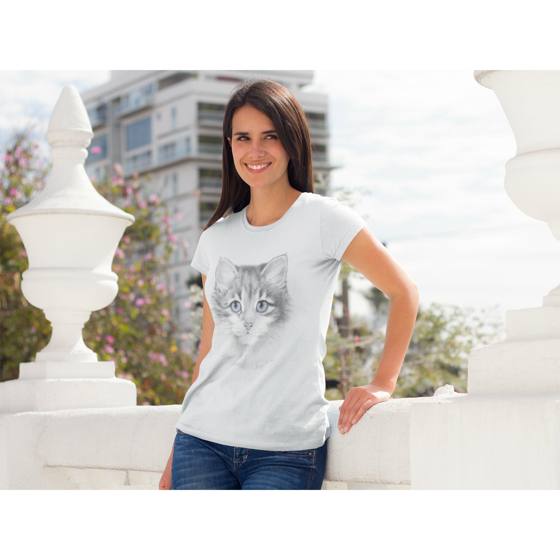 Girl wearing a Tee Shirt with a Black & White Kitten with Lavender Eyes.